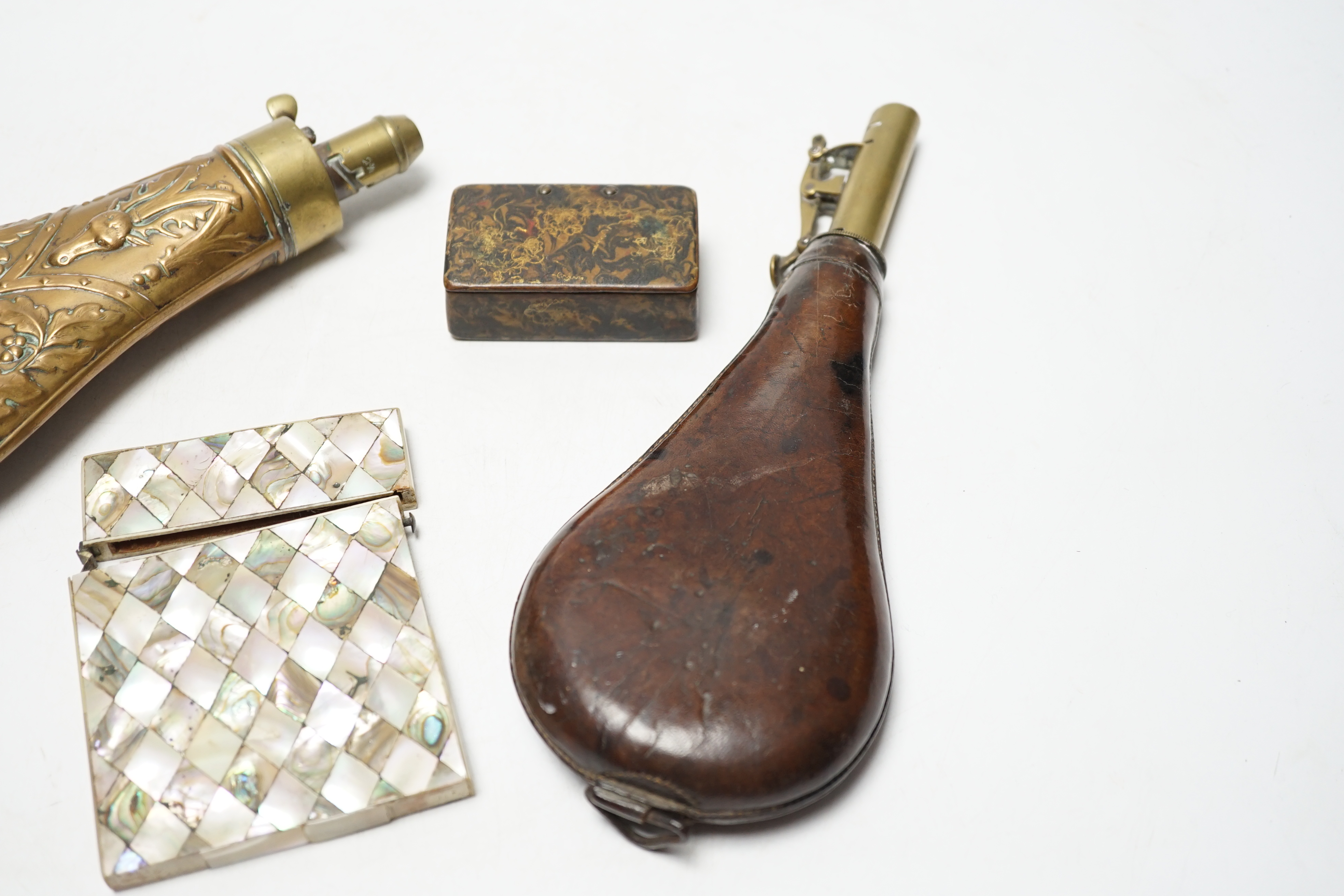 A Victorian embossed brass powder flask, a leather shot flask and a Victorian mother of pearl and abalone calling card case